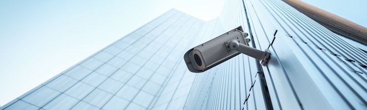 Up angle of security camera on high rise office building.