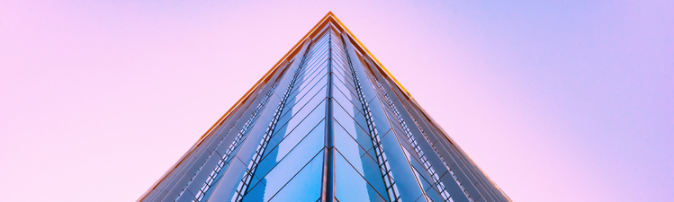 Up angle of glass skyscraper at sunset.