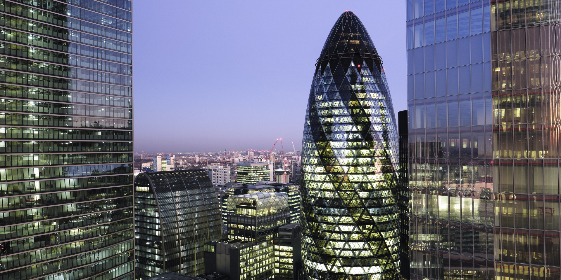 UK, London, looking East from above with view of high rise office towers illuminated at twilight