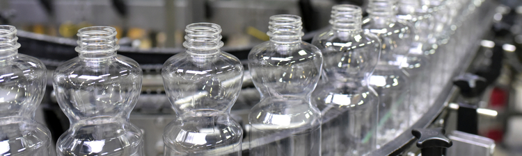 Close-up of plastic bottles on assembly line.