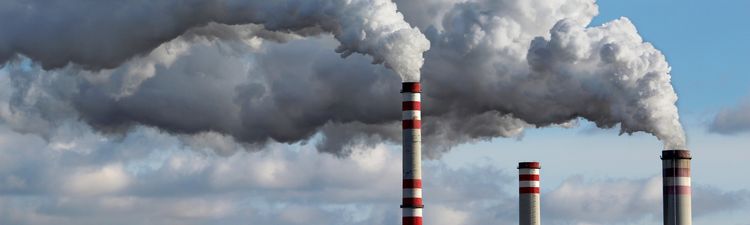Medium angle of power plant chimney or stack emitting white smoke.