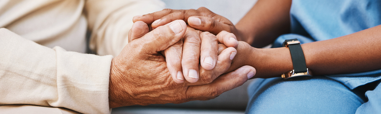 Nurse in blue scrubs holding hand of patient
