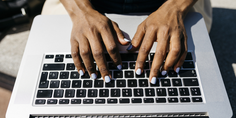 Businesswoman sitting on bench and using laptop finger typing