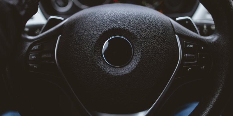 Steering wheel of luxury car with hand driving