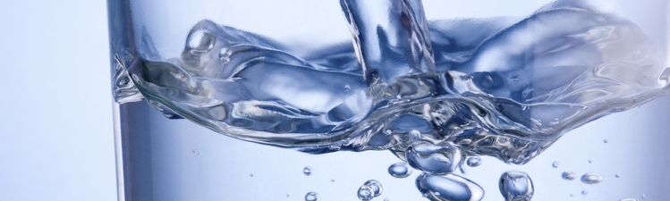 Close-up of water being poured into drinking glass.