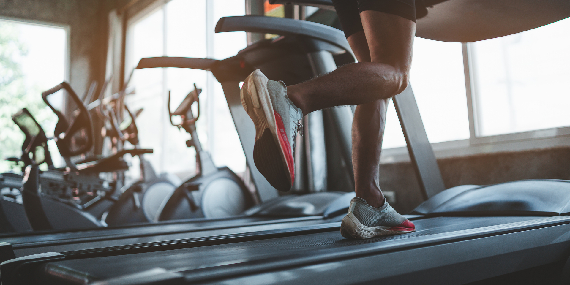 Close up of feet, sportman runner running on treadmill in fitness club. Cardio workout. Healthy lifestyle, guy training in gym. Sport running concept