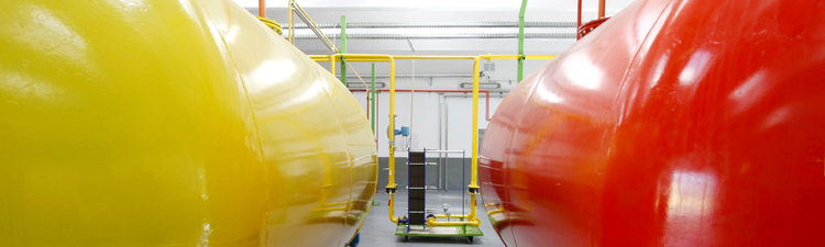 Medium angle of yellow and red fuel storage tanks.