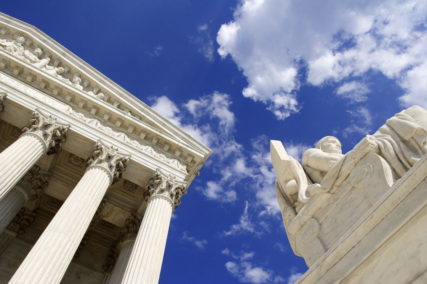 Up angle of the Authority of Law statue in front of the West Facade of the United States Supreme Court Building.