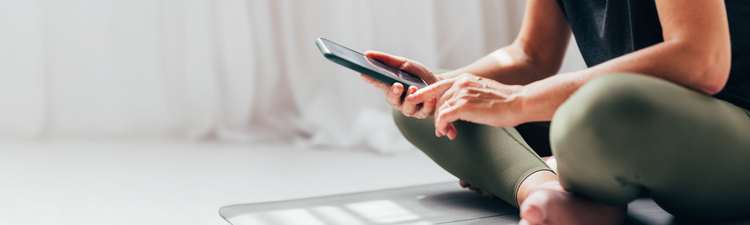 Woman Using Smartphone on Yoga Mat During Break