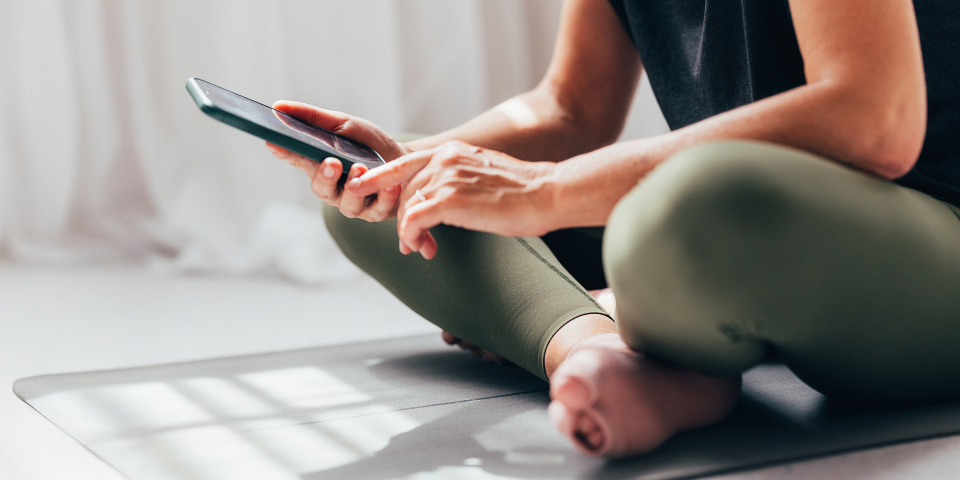 Woman Using Smartphone on Yoga Mat During Break