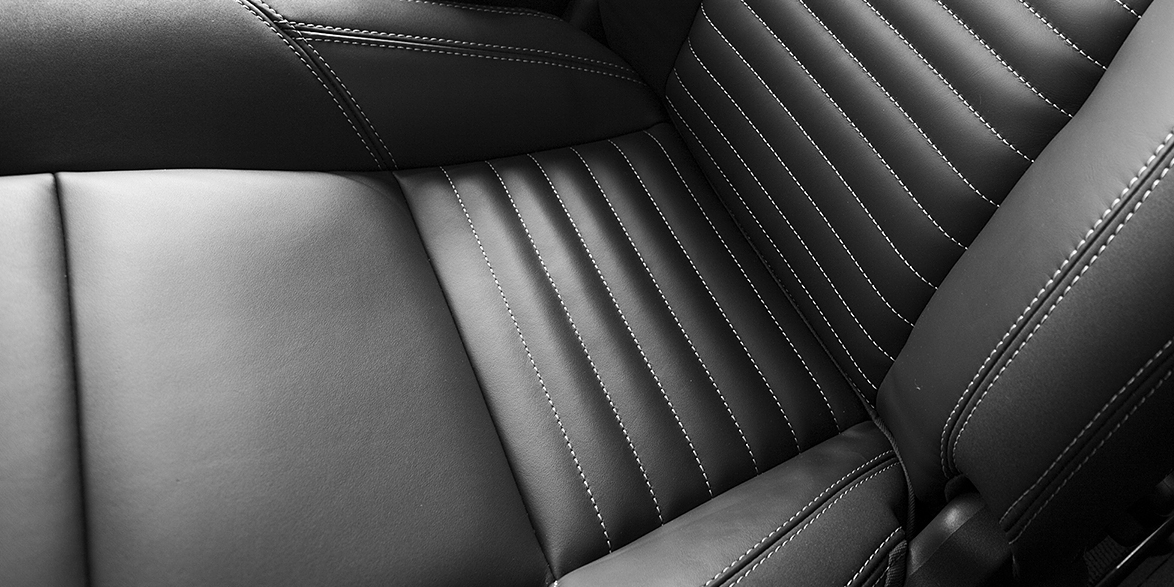 Close-up of black leather driver and passenger seats in a car.