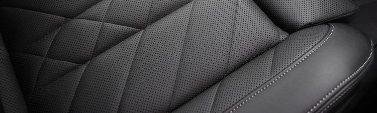 Extreme close-up of black perforated leather in car.