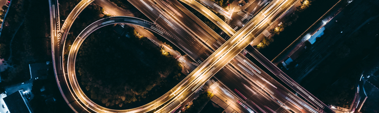 High angle down of circular freeway ramps at night. 