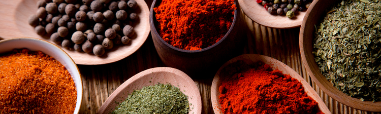 Close-up of assorted spices on wooden background.