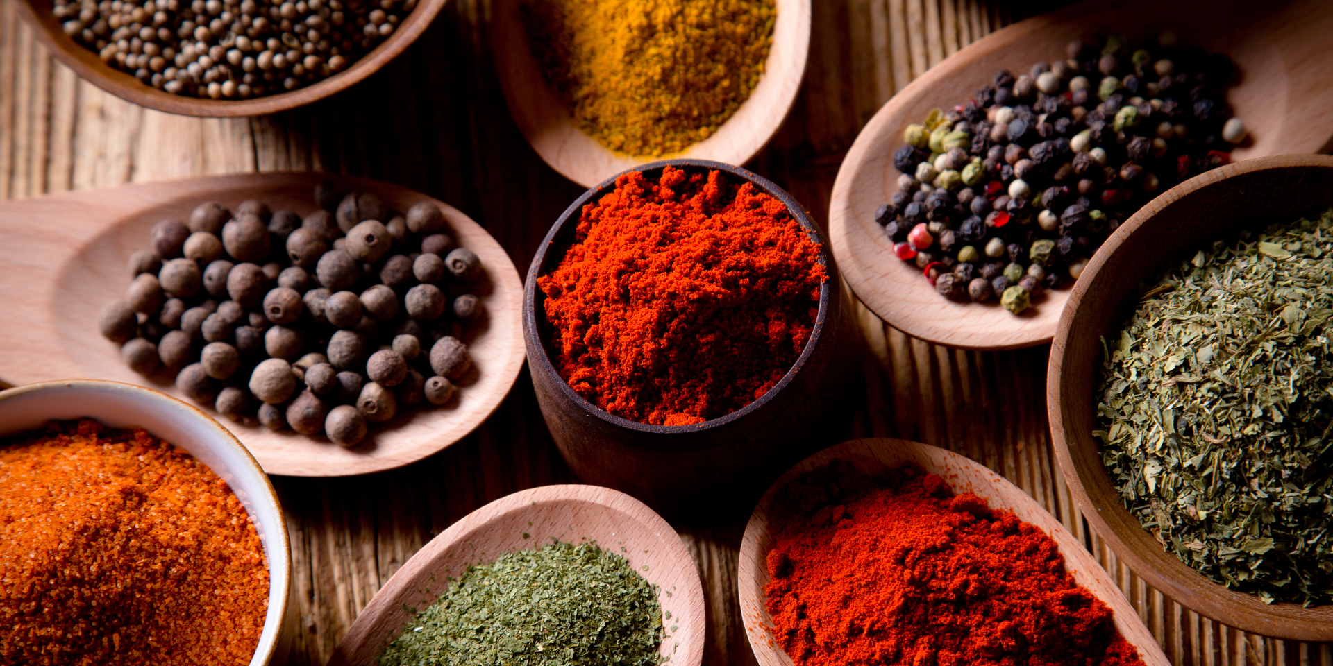Close-up of assorted spices on wooden background.