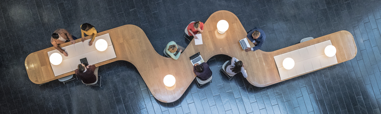 High angle down of coworkers meeting in communal area of a modern office space.