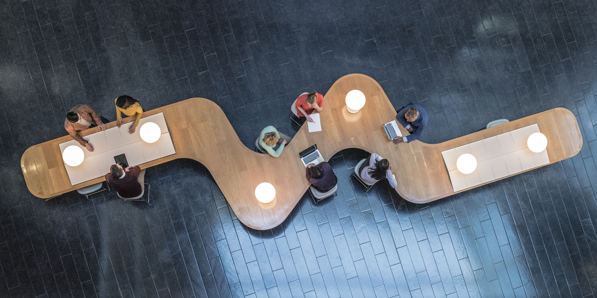 High angle down of coworkers meeting in communal area of a modern office space.