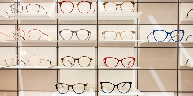 Rack with frames for glasses in optician shop. Variety of eyeglasses frames on store display.
