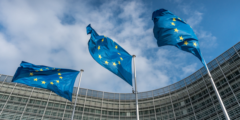 Up angle of European Union flags at Berlaymont Building, headquarters of the European Commission in Brussels, Belgium.