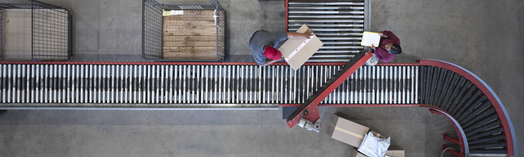 High angle down over conveyor belt in processing warehouse.