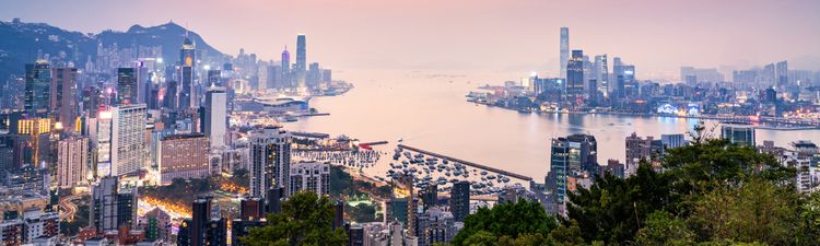 Wide angle of Hong Kong city skyline and Victoria Harbor from Braemar Hill Peak at sunset.