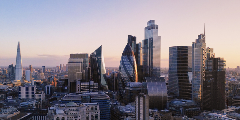 Wide angle of London financial district skyline at dusk.