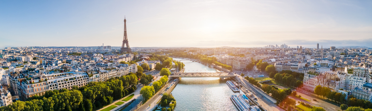 Aerial of Paris skyline with Eiffel Tower and Seine River visible.