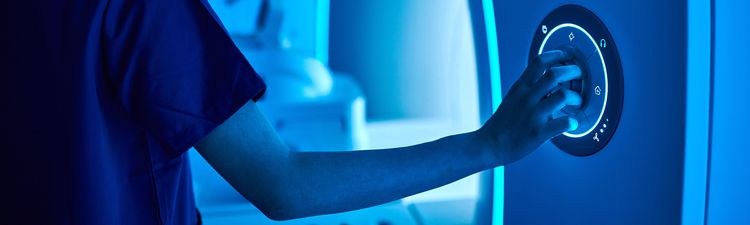 Close-up of nurse operating MRI machine.