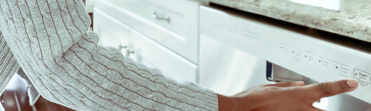 Close-up of woman pushing button on dishwasher control panel.