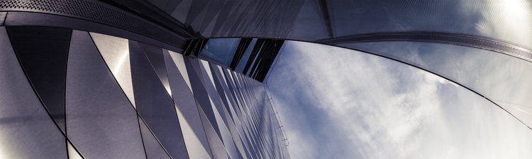 Up angle of modern skyscraper against blue sky and clouds.