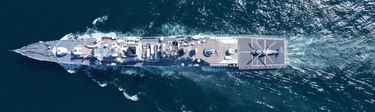 High angle down of military amphibious assault ship on ocean.