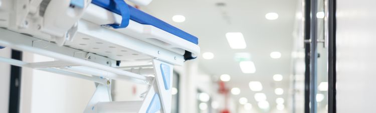 Close-up low angle of gurney in hospital hallway.