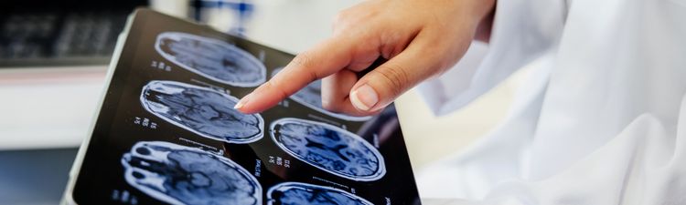 Close-up of medical professional reviewing medical imagery on digital tablet.