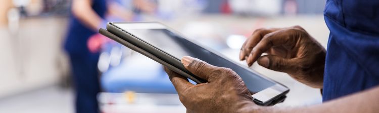 Close-up of medical professional in hospital reviewing medical imagery on digital tablet.
