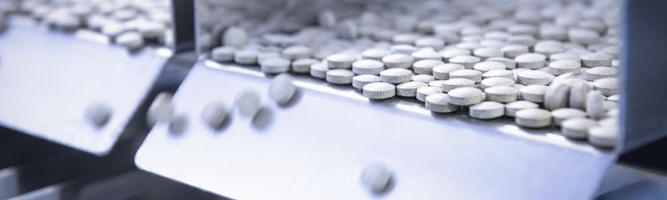 Close-up of tablet pills on pill counter or production line.