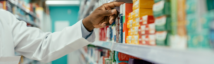 Medium angle of pharmacist looking for prescription drugs on a shelf in a pharmacy.