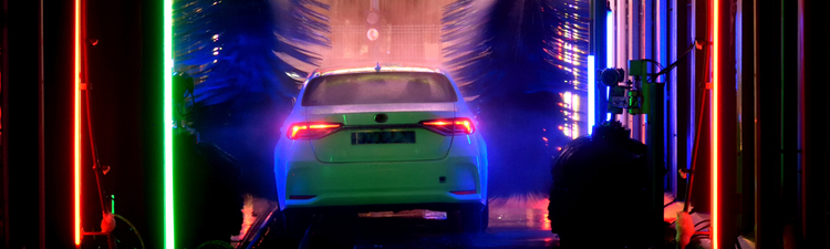  Wide angle interior of automatic car wash with neon lights at night.