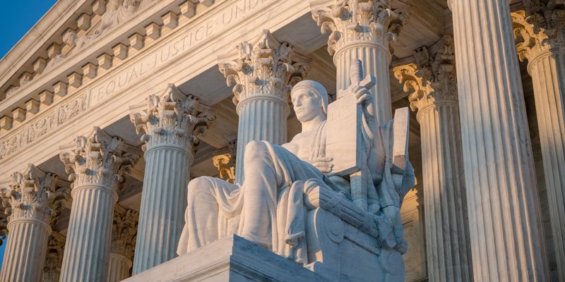 Medium angle of The Authority of Law Statue at the West Facade of the United States Supreme Court Building.