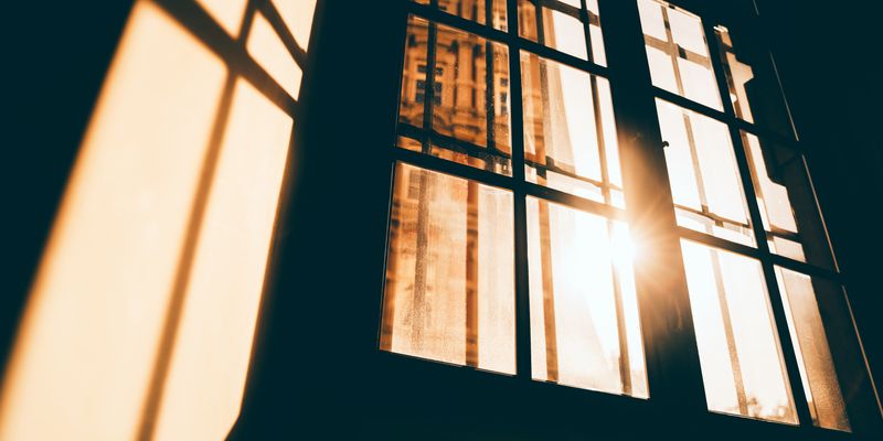 Up angle of sunlight streaming in through window panes.