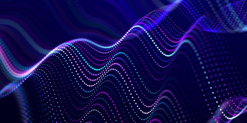 Medium angle of multicolored dots in wave pattern on blue background.