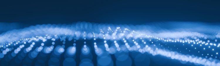Medium angle of glowing blue and white data points rippling across a fluid digital surface.