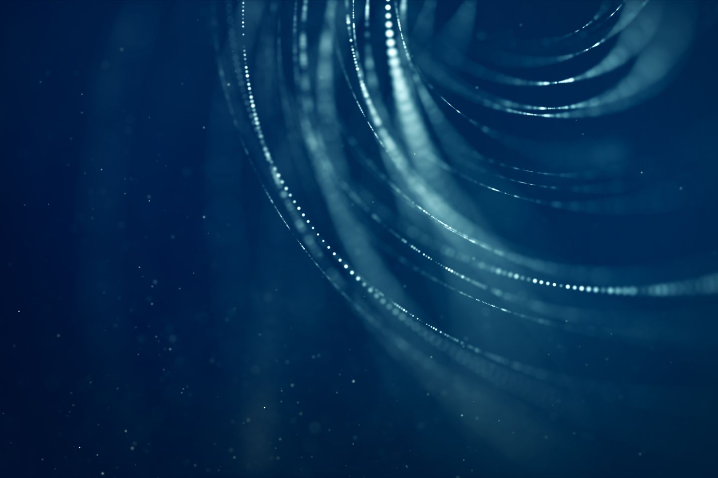 Medium angle of blue, curved light trails with glowing particles.