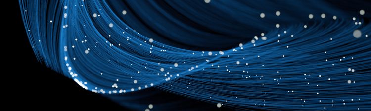 Medium angle of flowing blue light trails with glowing whitep articles.