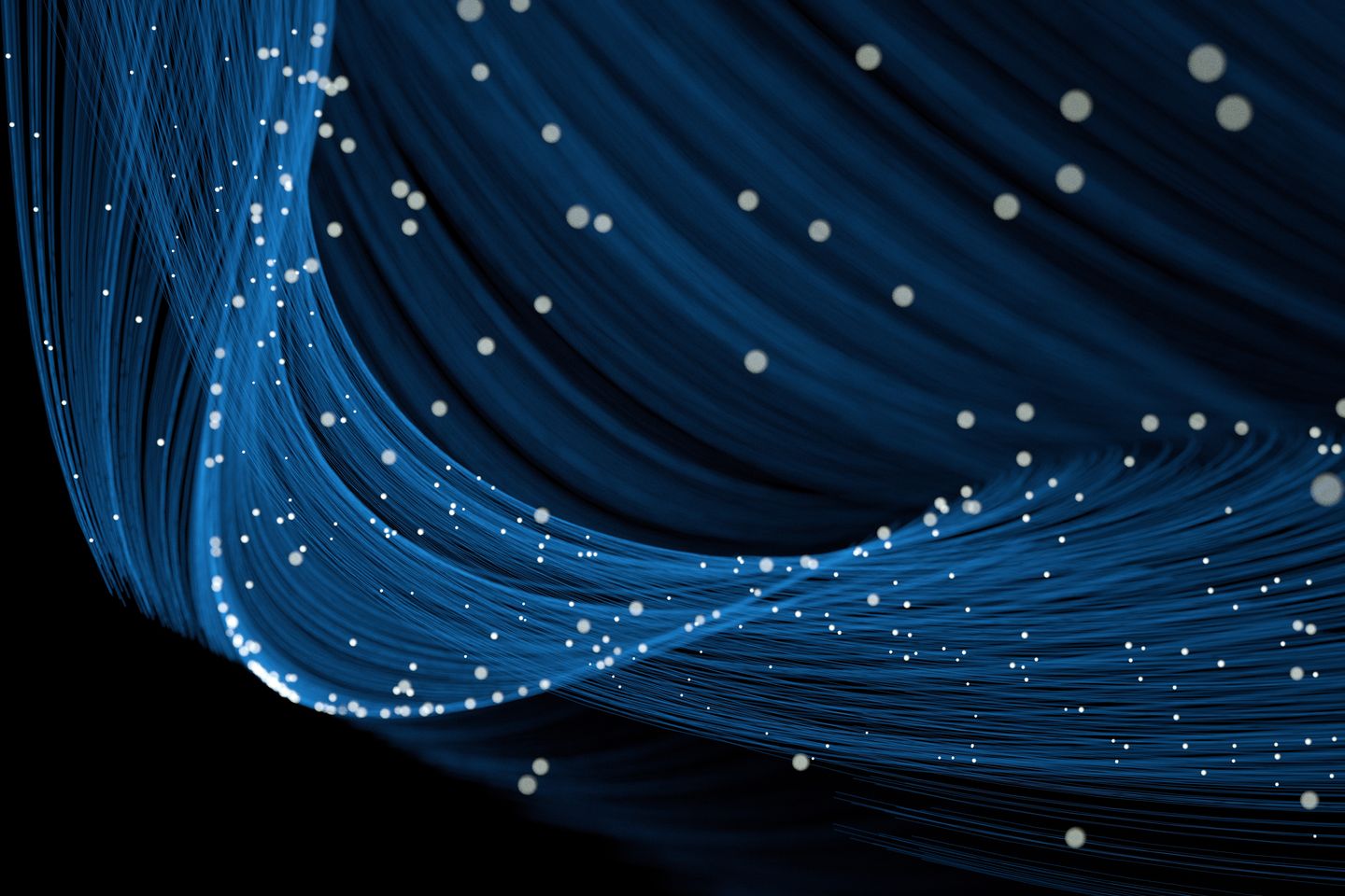 Medium angle of flowing blue light trails with glowing whitep articles.
