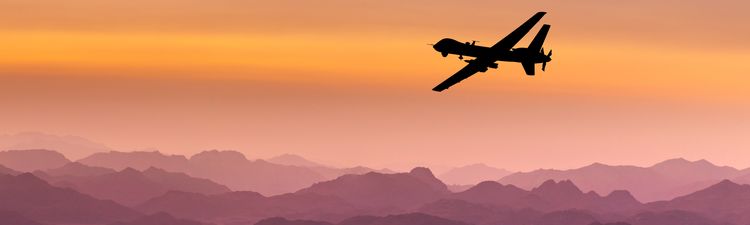 Wide angle of unmanned aerial vehicle (UAV) flying over mountains at sunset.