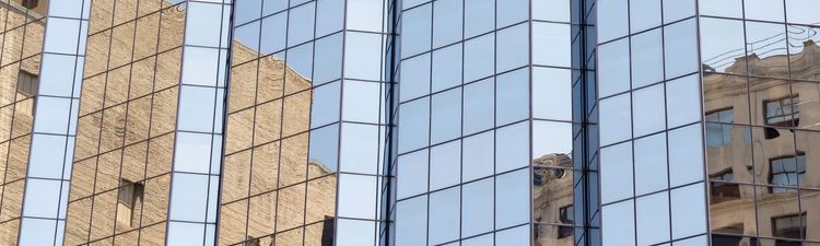 Medium angle of building reflected in mirrored glass windows. 