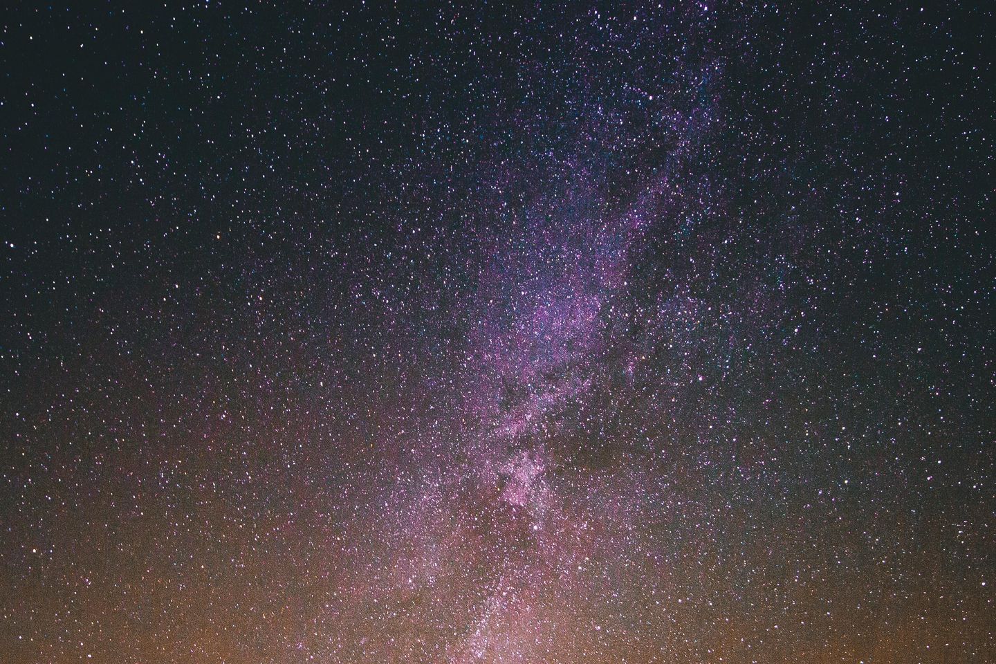 Wide angle of silhouetted person standing against starry night sky.
