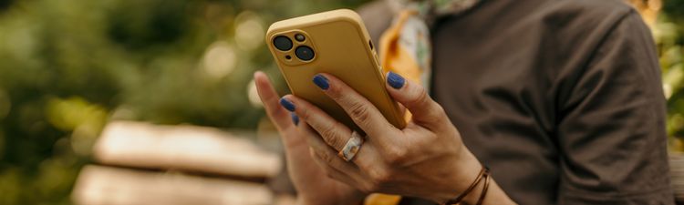 Medium angle of woman browsing smartphone on park bench.