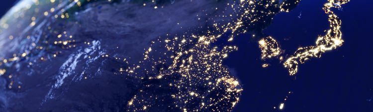 Medium angle of Earth from space with city lights visible over Asia.