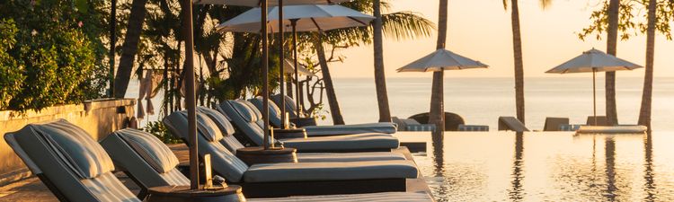 Wide angle of swimming pool at resort hotel at sunset.